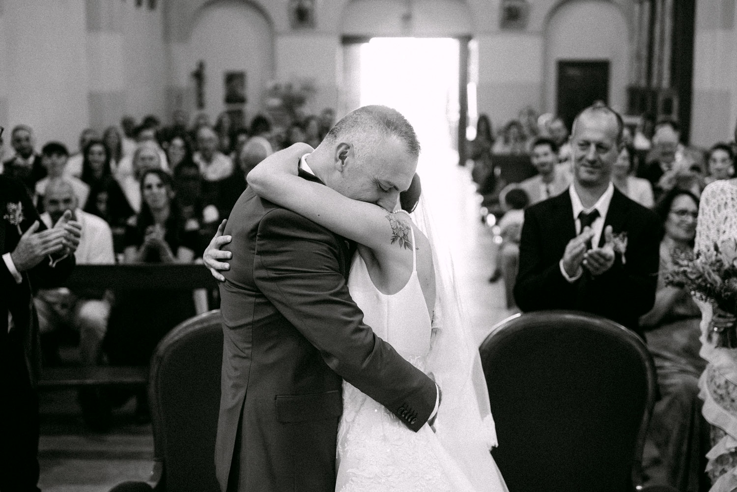 Mariés s’enlaçant lors de la cérémonie entourés de leurs proches – photographe de mariage Pyrénées-Orientales