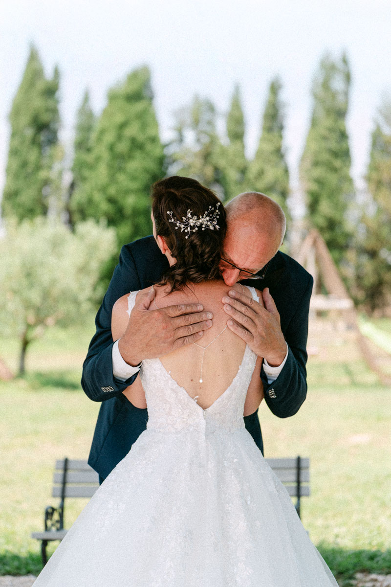 Mariés s’embrassant dans un parc avec banc et chaise en arrière-plan – photographe de mariage Pyrénées-Orientales