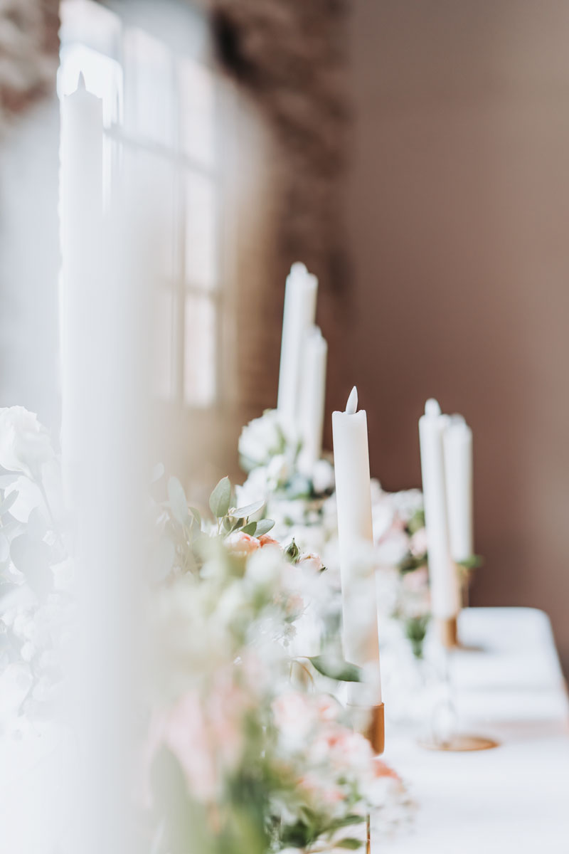 Bougies blanches et plantes en pots disposées sur une table – photographe de mariage Pyrénées-Orientales
